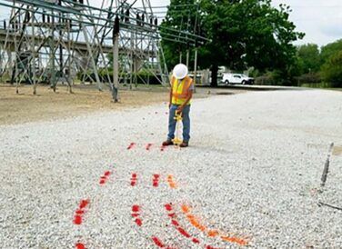 field crew member painting lines on road